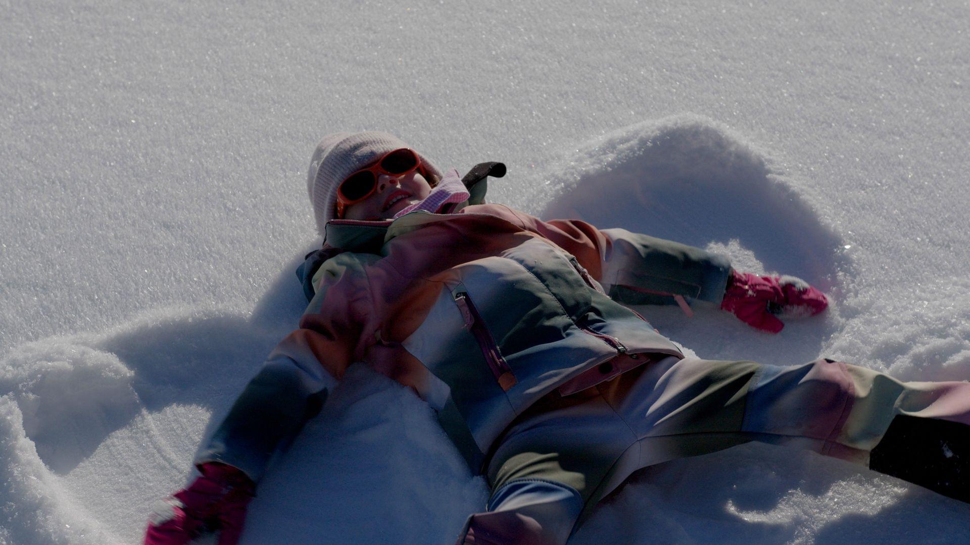 Familienurlaub – Kind beim Schneeengel machen – Winterurlaub – Torghele's Wald und Fluh